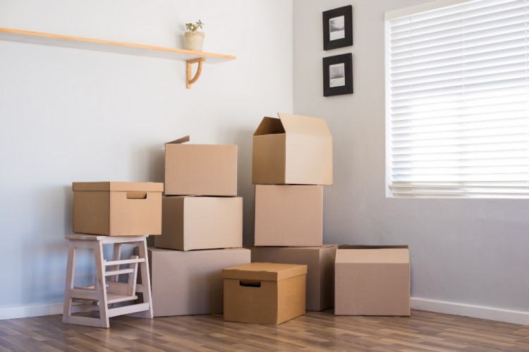 moving boxes piled up in the corner of a room 