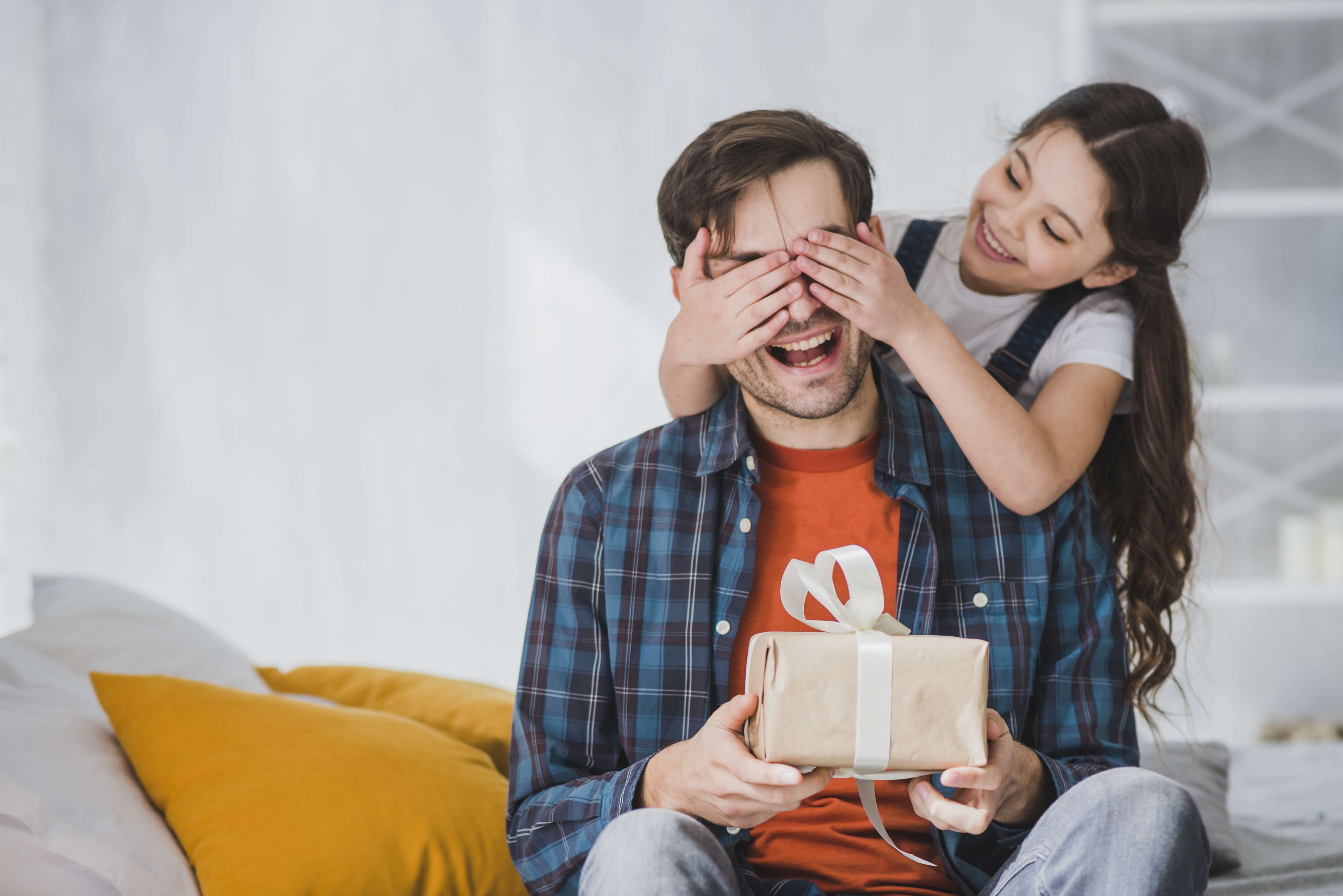 girl giving gift to father